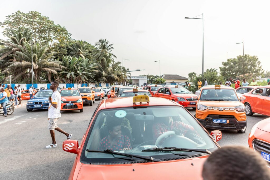 Rue animée d'Abidjan avec taxis et passants