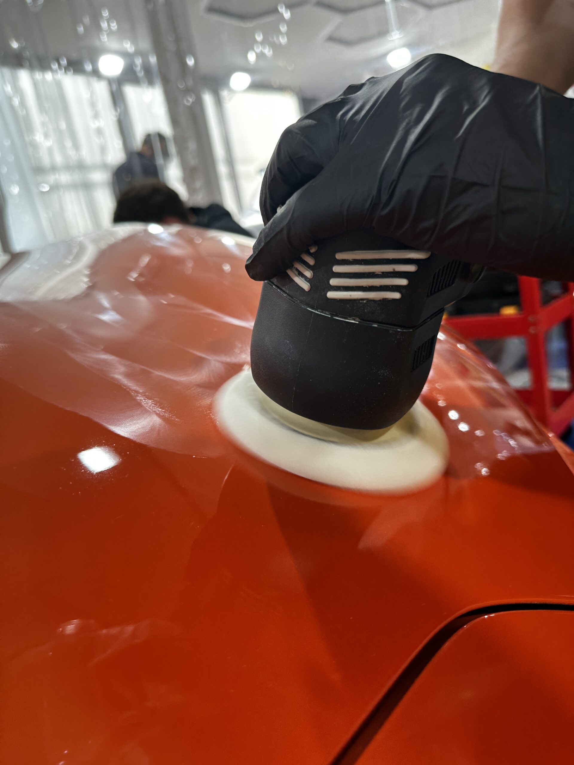 Polisseuse orbitale sur une carrosserie rouge