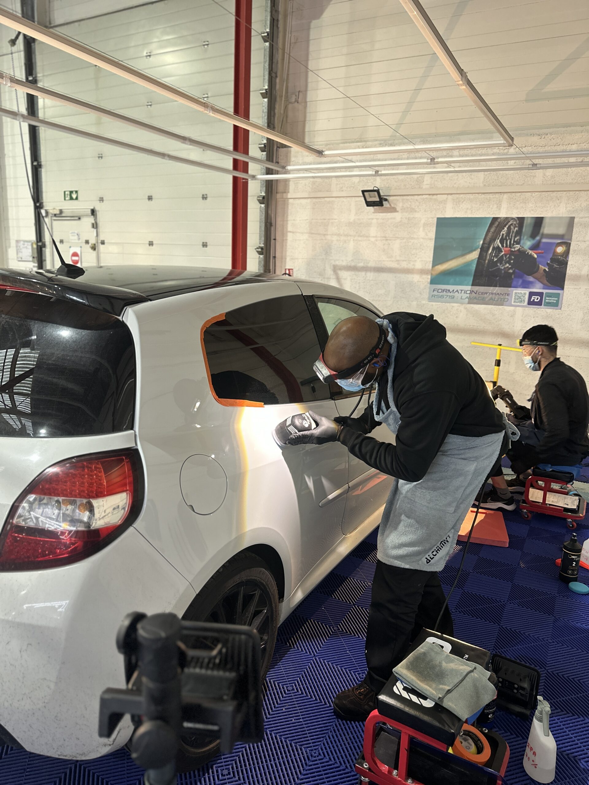 Session pratique en atelier sur un véhicule blanc