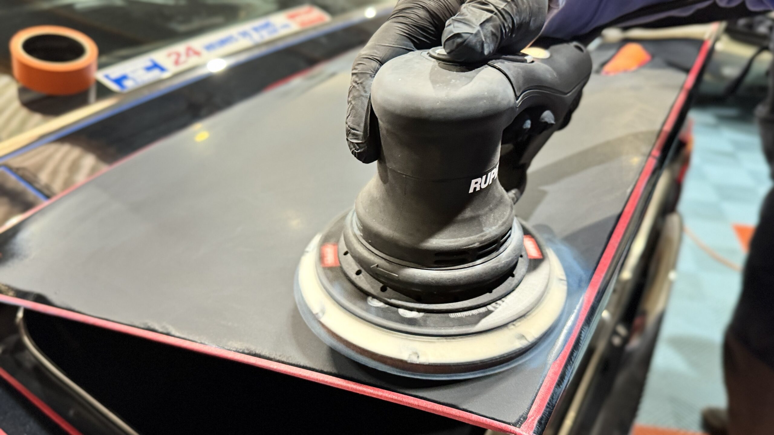 Ponceuse orbitale sur un élément de carrosserie