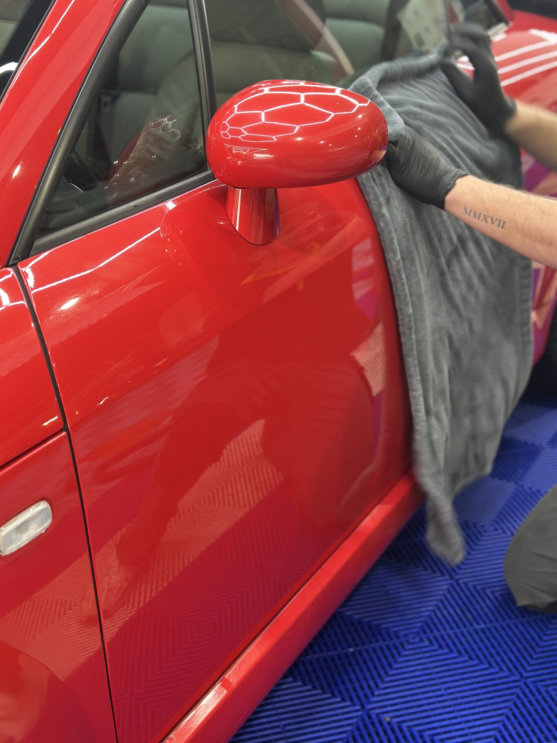 Finition à la microfibre sur une carrosserie rouge après poli-lustré